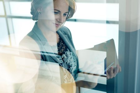 Filtered portrait of an executive business woman writing on a glass wall at sunset