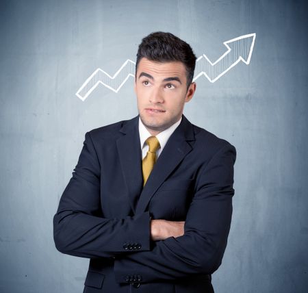 A handsome sales guy standing in front of a blue urban concrete wall with illustration of white graph chart arrows cocncept