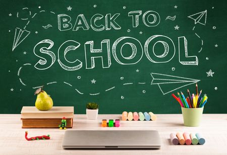 Back to school concepty with writing on blackboard and desk, apple, books, items