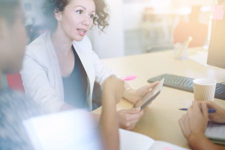 Unposed group of creative business people in an open concept office brainstorming their next project.