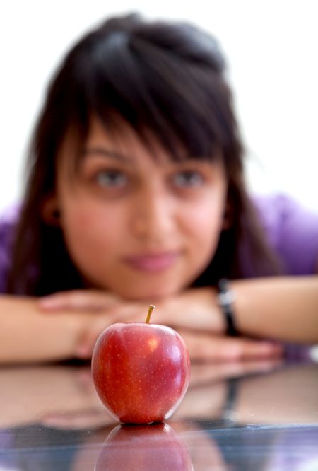 Pensive woman with an apple isolated on white
