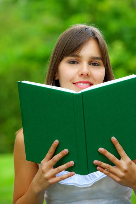 Female student smiling with a notebook outdoors
