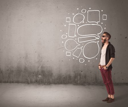 A comic hipster guy shouting in front of grey urban concrete wall with drawn empty text bubbles around his mouth concept