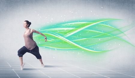 A good looking fresh street dancer dancing in front of grey background with white and bright, colorful green lines concept