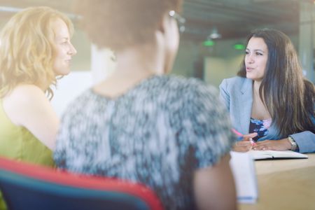 Unposed group of creative business people in an open concept office brainstorming their next project.