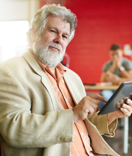 Confident male designer working on a digital tablet in red creative office space