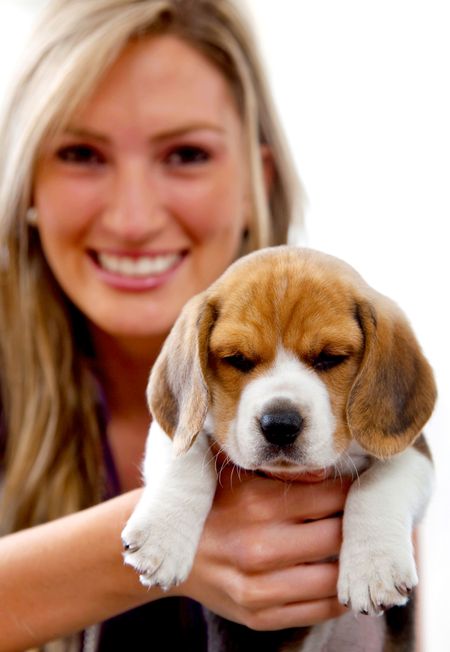 Beautiful woman smiling holding a puppy isolated