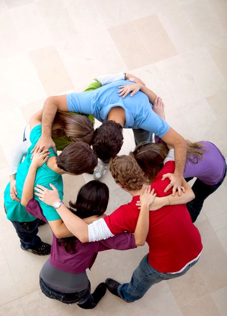 Picture of a team of people hugging indoors