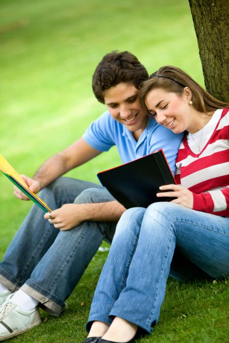 Couple of young students with notebooks outdoors