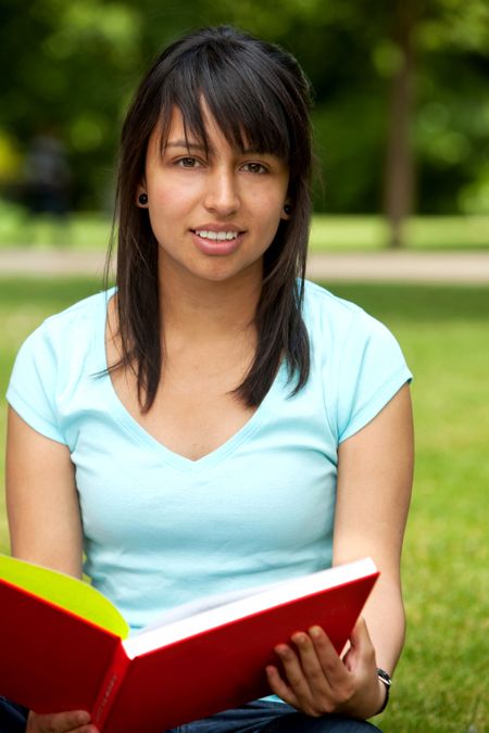Girl portrait with a book smiling outdoors