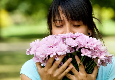 Woman smelling a bouquet of flowers outdoors