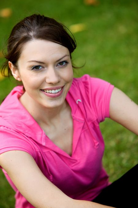 Beautiful sporty woman portrait sitting outdoors smiling