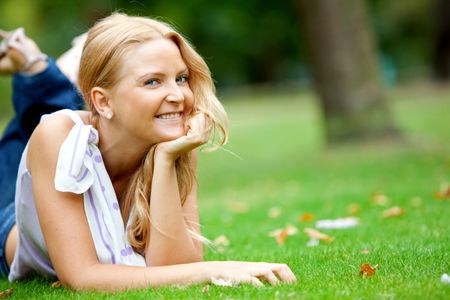 Beautiful woman portrait lying outdoors and smiling