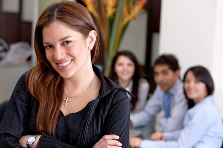 business-woman-smiling-office-team-40593388 Business woman smiling in an office with her team behind her