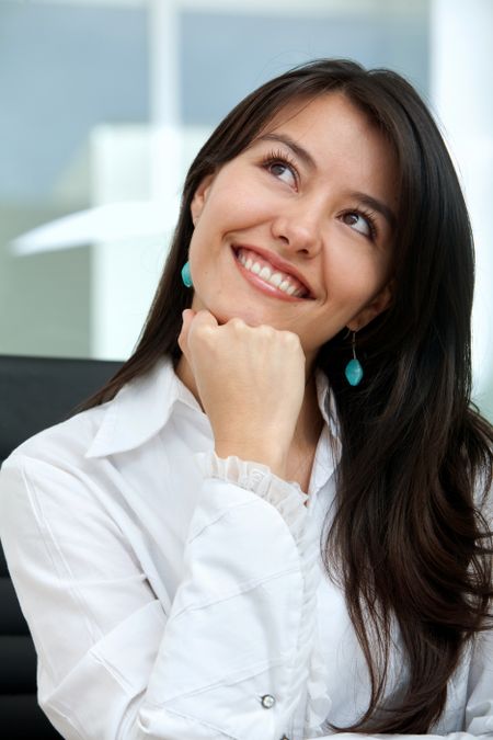 pensive business woman smiling in an office