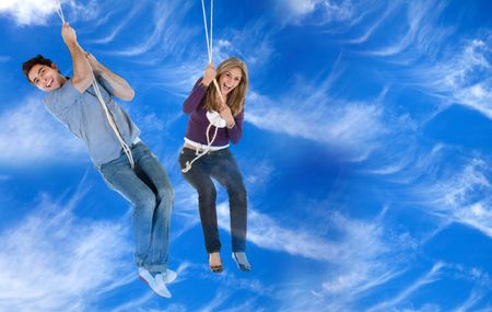 Happy couple hanging from a rope smiling