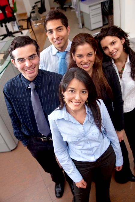 Business team standing at an office smiling