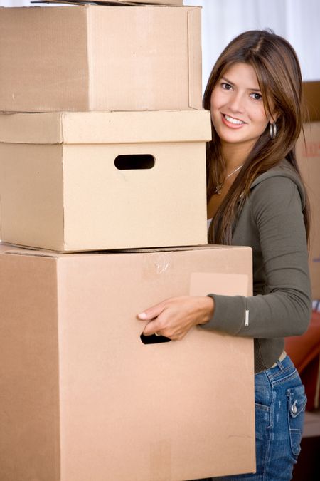 Beautiful woman moving house and carrying boxes