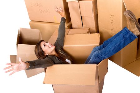 pretty woman sitting inside a box among a stack of moving boxes