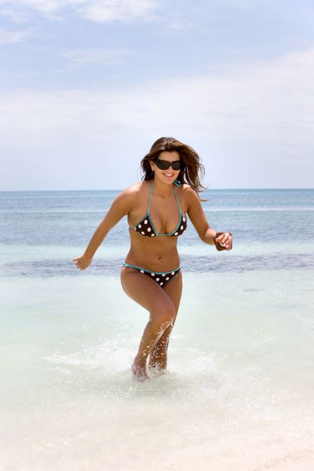beautiful bikini girl running and having fun at the beach