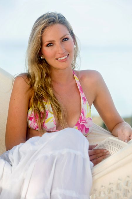 Beautiful woman sitting on a hammock at the beach while on vacation
