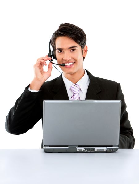 Customer services man at his desk on a laptop computer smiling - isolated over a white background