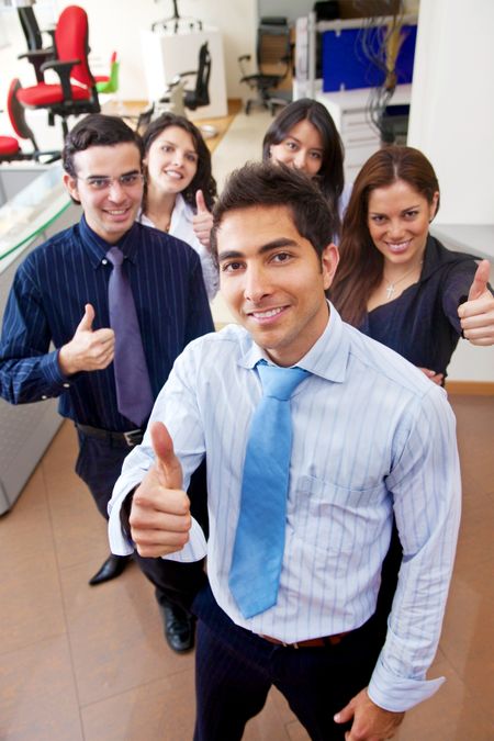 Business people with thumbs up in an office