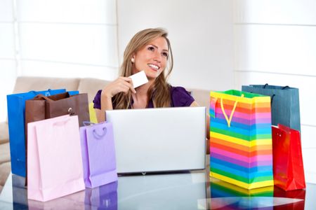 Thoughtful woman portrait shopping online with bags