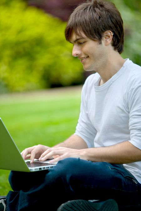 Young man working on a computer outdoors
