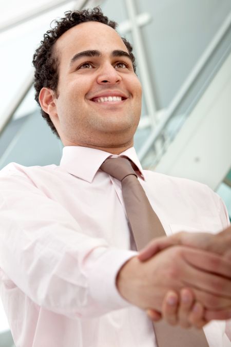 business-man-giving-handshake-office-40726255 Business man giving a handshake at an office