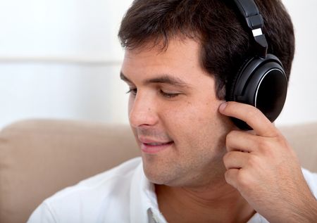 Man with headphones at home listenting to music
