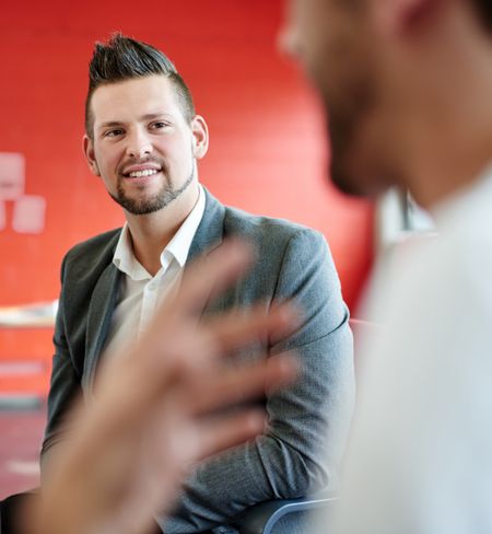 Unposed group of creative business people in an open concept office brainstorming their next project.