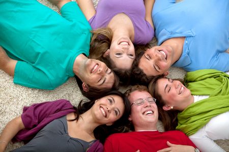 happy group of friends with heads together on the floor