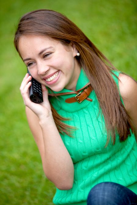 Happy girl talking on the phone outdoors