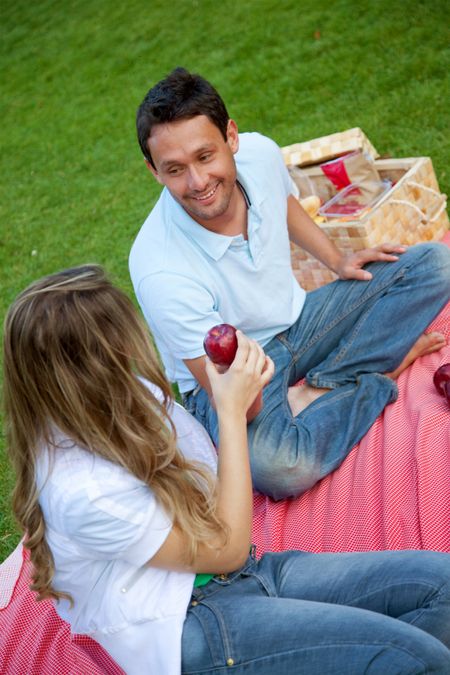 Beautiful happy couple having a picnic at the park