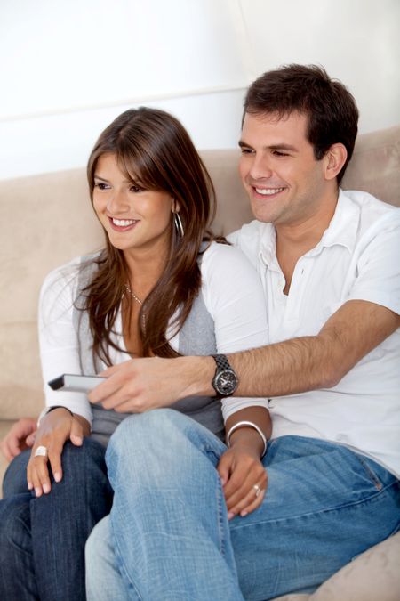 beautiful couple relaxing and watching tv at home