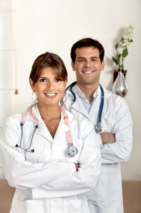 couple of doctors holding a stethoscope and smiling in a hospital