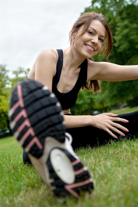woman doing stretching exercises on the floor outdoors