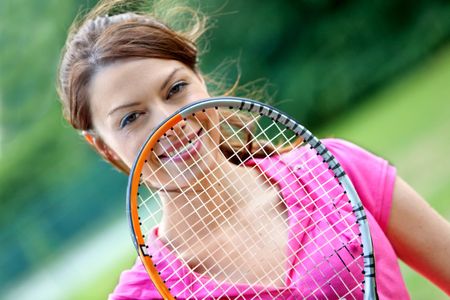 Female tennis player with a racket outdoors