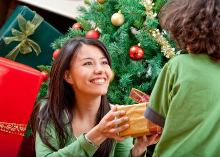 Woman giving a Christmas present to a boy