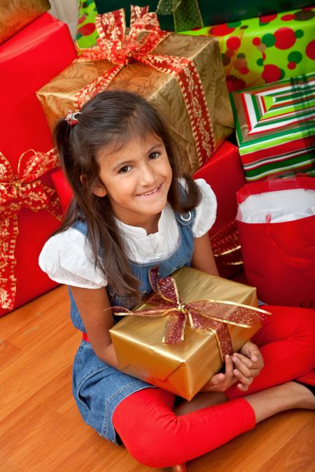 Girl next to a Christmas tree with gifts