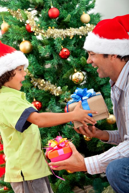 Boy giving a Christmas gift to his father