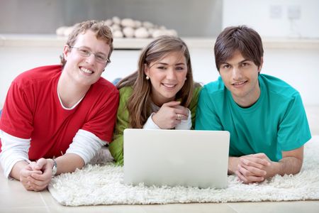 Group of casual people with a computer lying on the floor