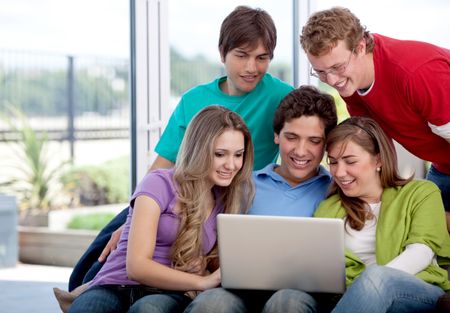 Happy group of friends with a laptop indoors