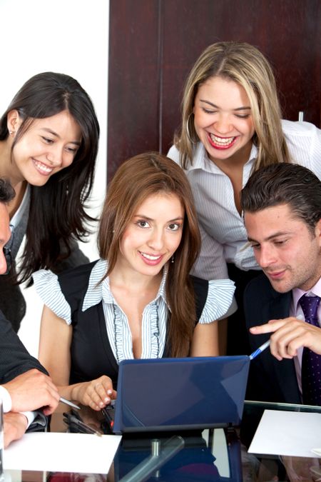 Business people with a laptop smiling at the office