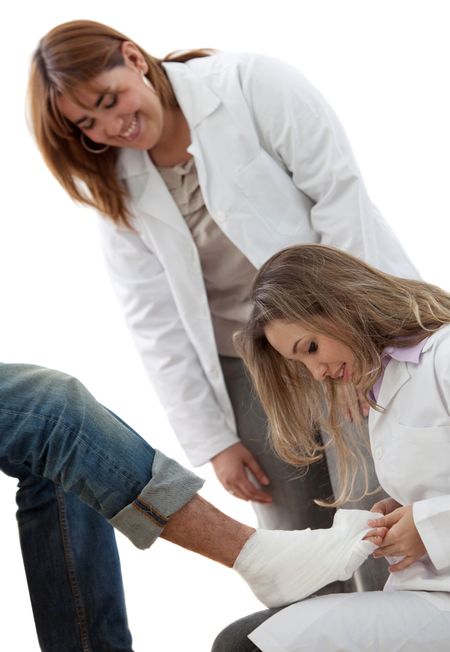doctors putting a cast on a patient leg isolated over a white background