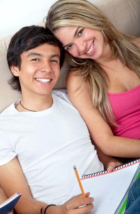 Lovely couple of students with notebooks at home