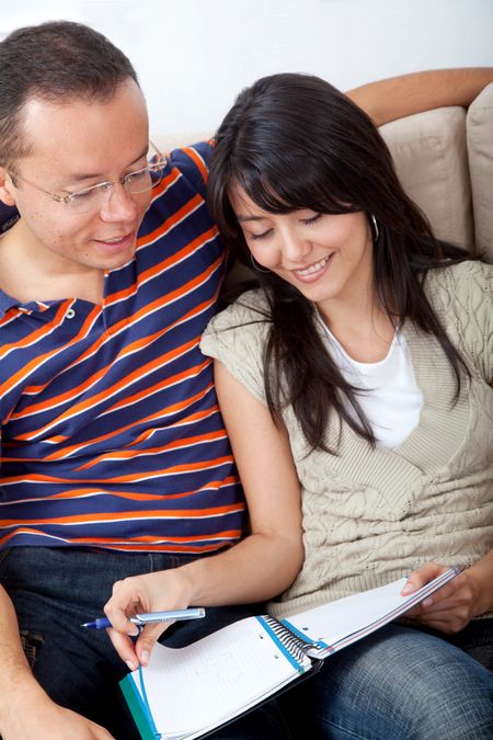 Lovely couple of students with notebooks at home