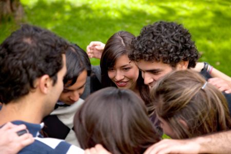 group of friends hugging and planning a strategy outdoors