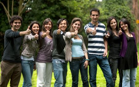 Large group of friends with thumbs up smiling outdoors